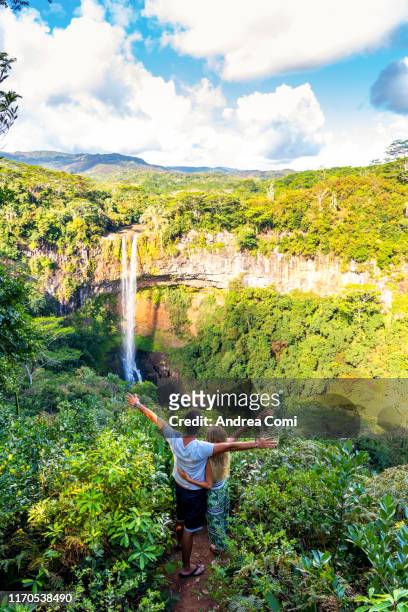 a couple admiring the view of the chamarel waterfall - mauritius stockfoto's en -beelden