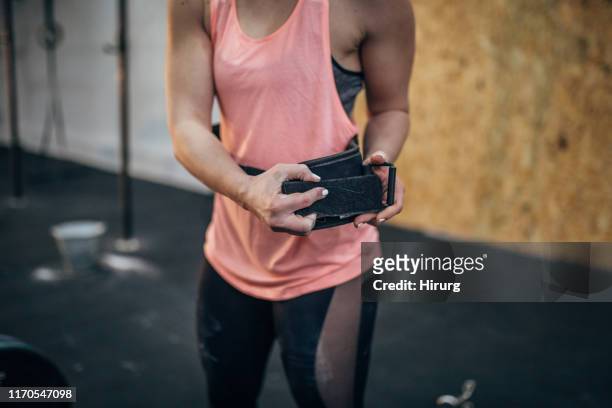 woman putting on belt for dead lift training - belt stock pictures, royalty-free photos & images