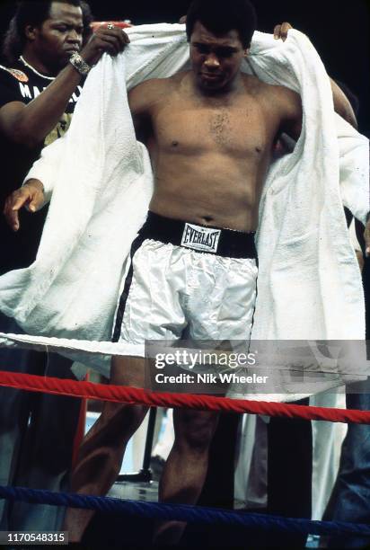 Heavyweight boxing champion Muhammad Ali takes off his robe before a sparring and training session in gym days before bout with Joe Frazier circa...