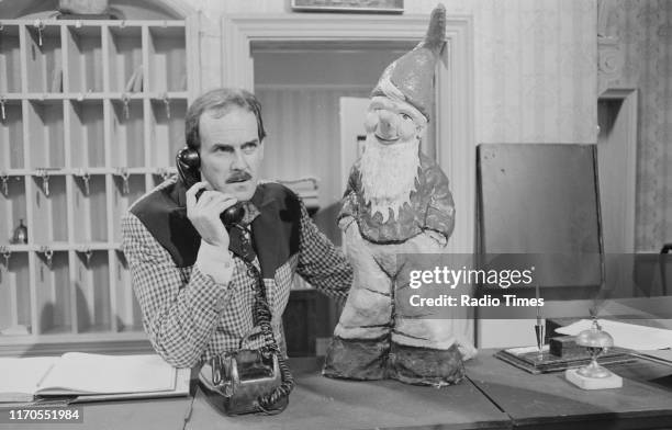 Actor John Cleese with a garden gnome in a scene from episode 'The Builders' of the BBC television sitcom 'Fawlty Towers', August 3rd 1975.