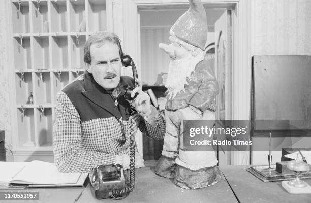 Actor John Cleese with a garden gnome in a scene from episode 'The Builders' of the BBC television sitcom 'Fawlty Towers', August 3rd 1975.