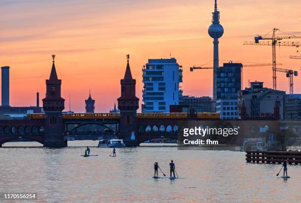 stand-up-paddlers on spree river (berlin, germany) - kreuzberg - fotografias e filmes do acervo