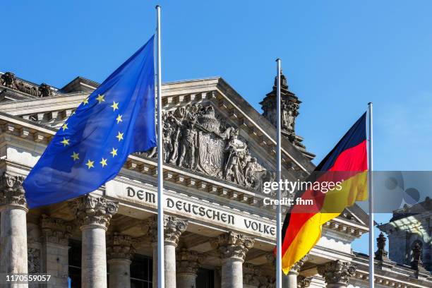 inscription on the architrave on the reichstag building: "dem deutschen volke" with german and eu-flag (berlin, germany) flag - flagge europa stock-fotos und bilder