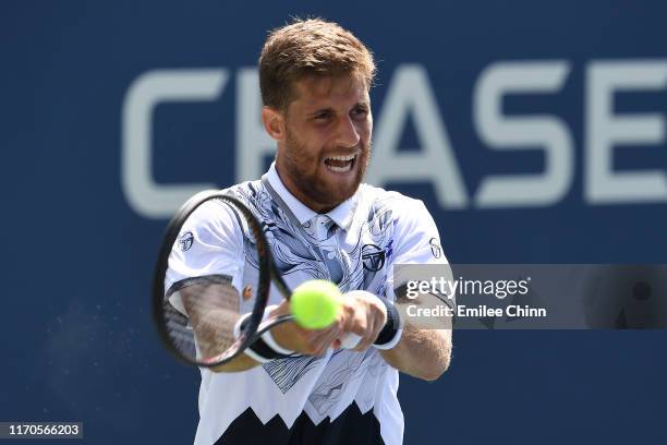 Martin Klizan of Slovakia returns a shot against Marin Cilic of Croatia during their Men's Singles first round match on day two of the 2019 US Open...