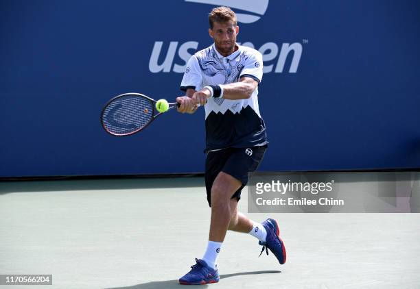 Martin Klizan of Slovakia returns a shot against Marin Cilic of Croatia during their Men's Singles first round match on day two of the 2019 US Open...