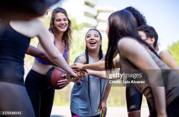 team of female basketball players stacking hands - competition round photos et images de collection