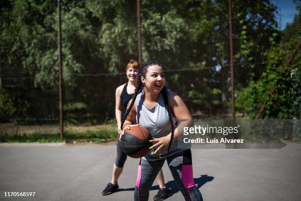 females enjoying playing basketball on court - street basketball imagens e fotografias de stock