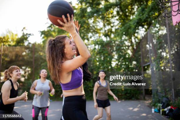 multi-ethnic female friends having fun playing streetball - basketball blocking shot stock pictures, royalty-free photos & images