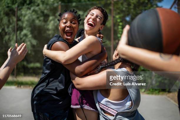female basketball team celebrating a victory - ethnische zugehörigkeit stock-fotos und bilder