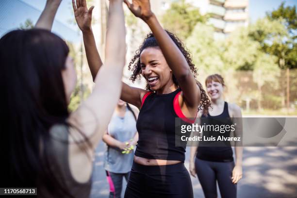 women giving each other high-five after basketball game - sport di squadra foto e immagini stock