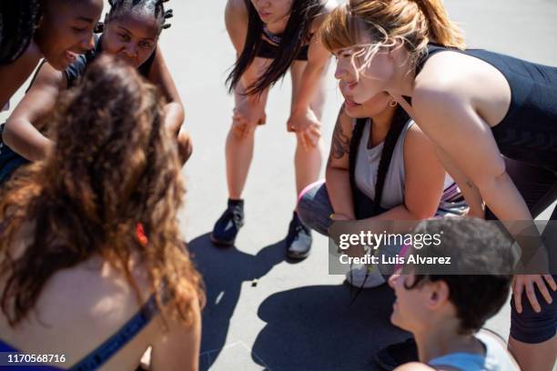 female basketball team discussing game plan - women's basketball bildbanksfoton och bilder