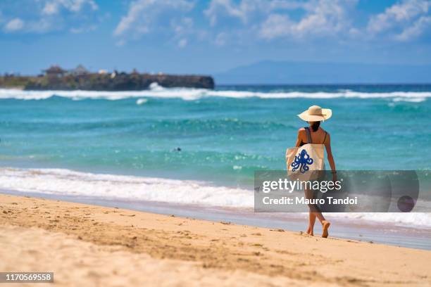 a woman walking nearby to the sea with a beautiful bag, nusa dua beach, bali, indonesia - nusa dua stock pictures, royalty-free photos & images