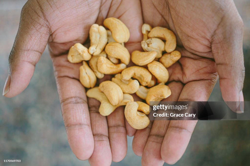 Close-Up View of Hands Holding Cashews