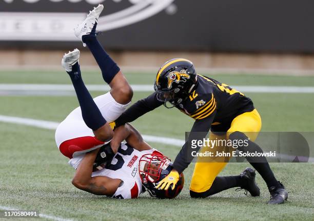Mike Jones of the Hamilton Tiger-Cats tackles Tommie Campbell of the Montreal Alouettes after an interception at Tim Hortons Field on June 28, 2019...