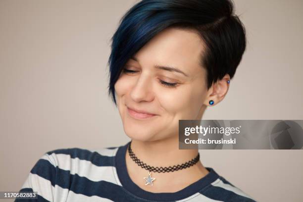 retrato de estudio de una atractiva mujer de 30 años con una camiseta a rayas sobre un fondo beige - short necklace fotografías e imágenes de stock