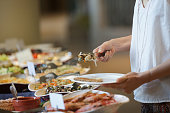 Woman taking food from a buffet line