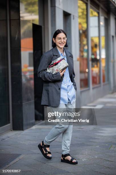 Maria Barteczko is seen wearing grey oversized blazer Badblood, blue striped blouse Chanel, grey sweatpants Nike, black chunky hiking sandals Asos,...