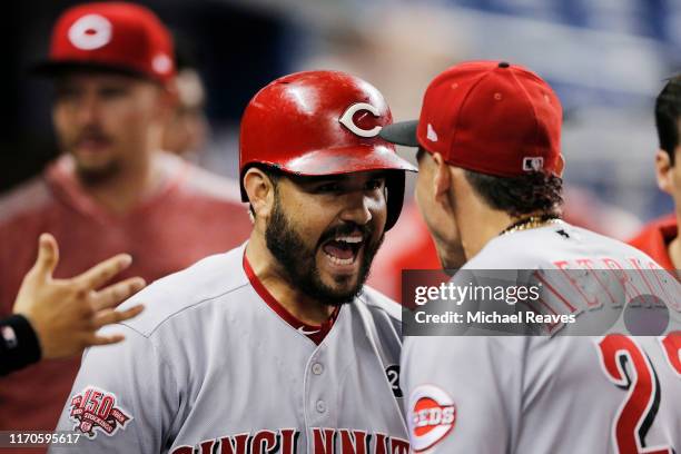 Eugenio Suarez of the Cincinnati Reds celebrates with Derek Dietrich after hitting a two-run home run during the first inning against the Miami...