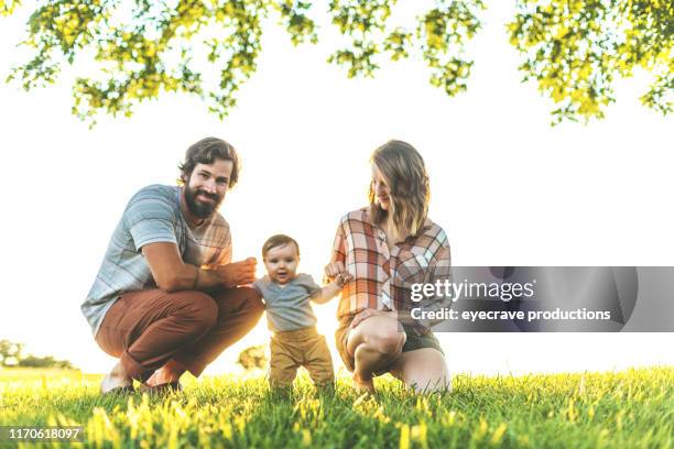 familiefoto's van twee generaties genomen in het openbare park weelderig groen gras en boom gebied in springfield missouri tijdens golden hour - springfield missouri stockfoto's en -beelden