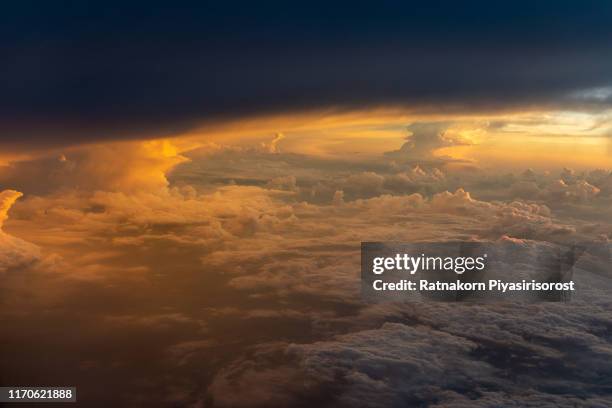 dramatic cloudscape view from the airplane to the sky during sunset. - airplane window exterior stock-fotos und bilder