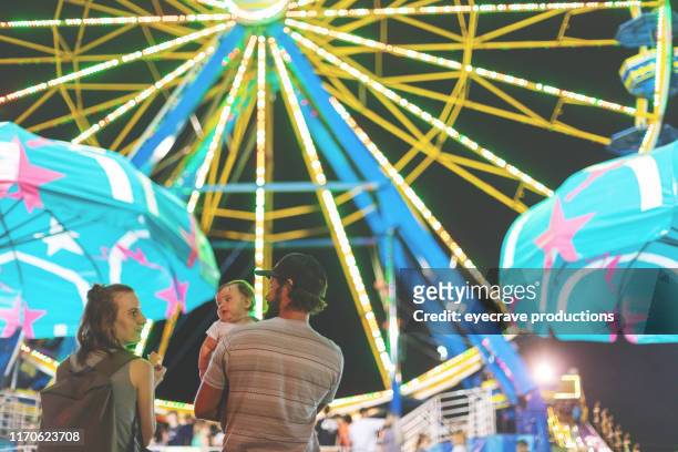 young millennial family enjoying their time at the empire state fair in springfield mo on a hot july summer night - springfield missouri imagens e fotografias de stock