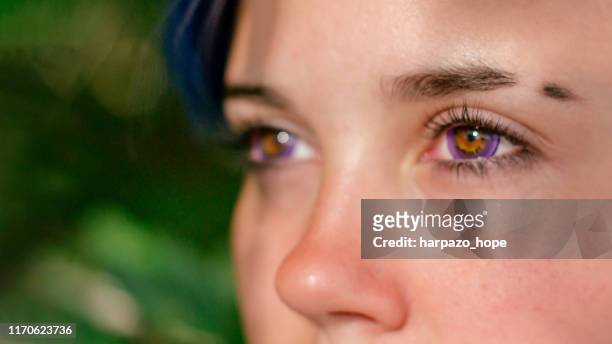 close-up of a teenager with purple colored contact lenses. - viola colore foto e immagini stock
