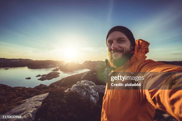 man travel adventures: mountain hiking in norway - digital handhold device stock pictures, royalty-free photos & images