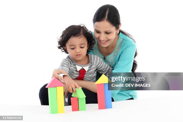 mother and child playing with foam blocks - indian baby boy stock pictures, royalty-free photos & images