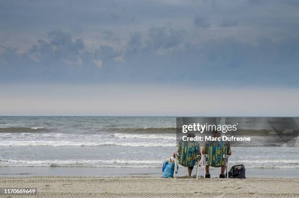 pareja sentada en la playa de atlantic city - atlantic city fotografías e imágenes de stock