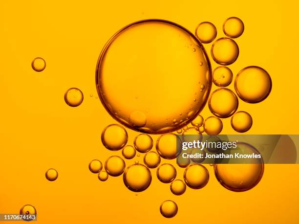 golden oil bubbles - huile de table photos et images de collection