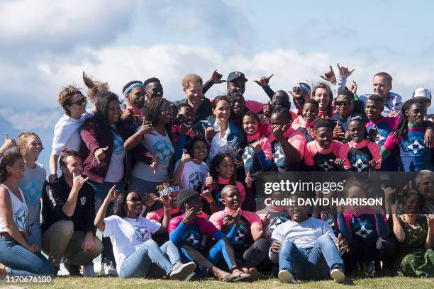 Prince Harry , Duke of Sussex and Meghan , Duchess of Sussex, pose with members of "Waves For Change" NGO at Monwabisi Beach outside of Cape Town on...