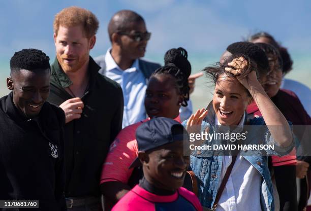 Prince Harry , Duke of Sussex and Meghan , Duchess of Sussex, pose with members of "Waves For Change" NGO at Monwabisi Beach outside of Cape Town on...