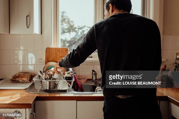 his turn to wash up - rear view hand window stockfoto's en -beelden