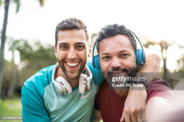two men taking a selfie in park - age difference couple stock pictures, royalty-free photos & images