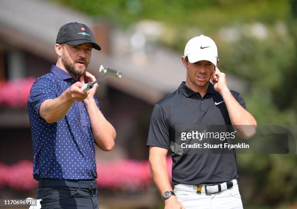Singer Justin Timberlake of USA and Rory McIlroy of Northern Ireland discuss during the pro-am prior to the start of the Omega European Masters at...