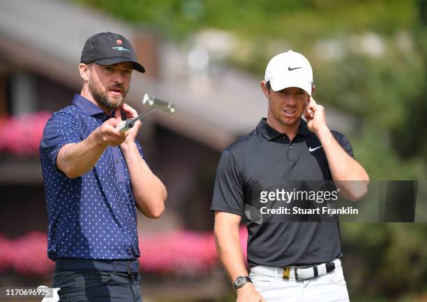 Singer Justin Timberlake of USA and Rory McIlroy of Northern Ireland discuss during the pro-am prior to the start of the Omega European Masters at...