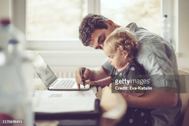 Fahter zeigt seiner Tochter Dinge auf einem Laptop