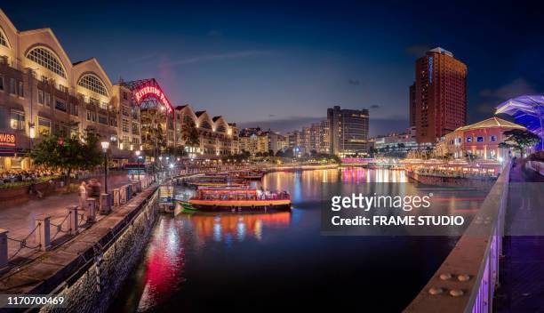 view of the river flanked by colourful buildings at dusk. - singapore imagens e fotografias de stock