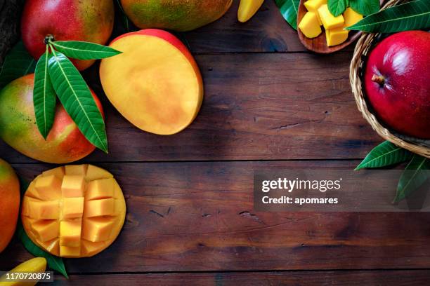 tropisch fruit: mand met mango's maken een frame met kopieer ruimte in rustieke keuken - raw mango stockfoto's en -beelden