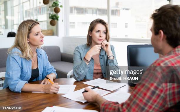 lesbian couple listening to financial planner - lesbian date stock pictures, royalty-free photos & images
