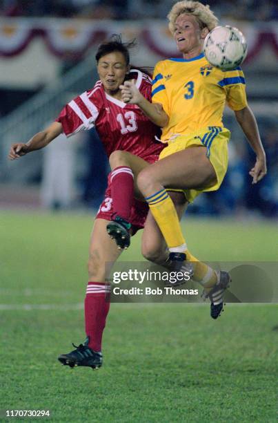 Niu Lijie of China and Anette Hansson of Sweden leap for the ball during play in the 1991 FIFA Women's World Cup quarter final match between China...