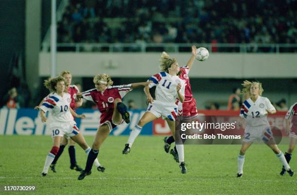 Team mates Michelle Akers and Carin Jennings look on as Julie Foudy of the United States leaps with Catherine Zaborowski of Norway for the ball...