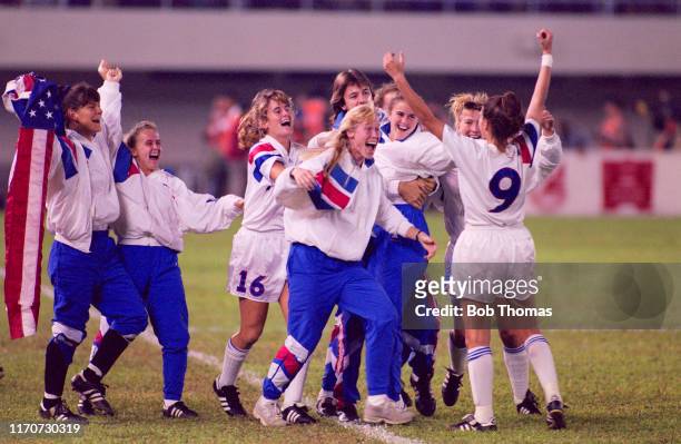 Mia Hamm raises her arms in the air as her team mates rush forward to celebrate after the United States beat Norway 2-1 in the final of the 1991 FIFA...