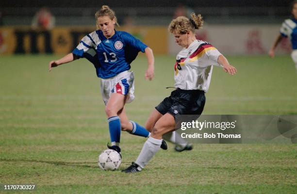 Frauke Kuhlmann of Germany kicks the ball away from Kristine Lilly of the United States during play in the 1991 FIFA Women's World Cup semi final...