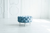 round blue pouf stool in white studio