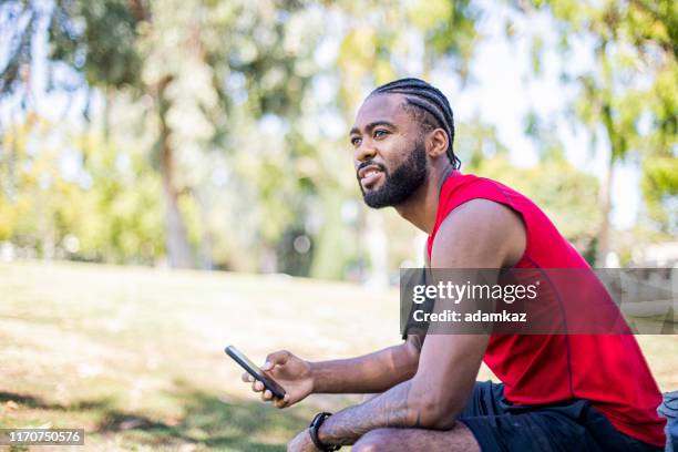 checking phone after workout - african cornrow braids stock pictures, royalty-free photos & images