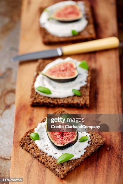 frische feigen mit ricotta-käse, frisches basilikum auf roggenbrot, overhead-blick. - offenes sandwich stock-fotos und bilder