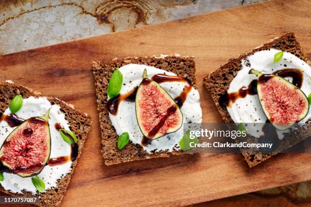 verse vijgen, ricotta, verse basilicum op roggebrood met uitzicht op de bovengrondse balsamicoazijn. - roggebrood stockfoto's en -beelden