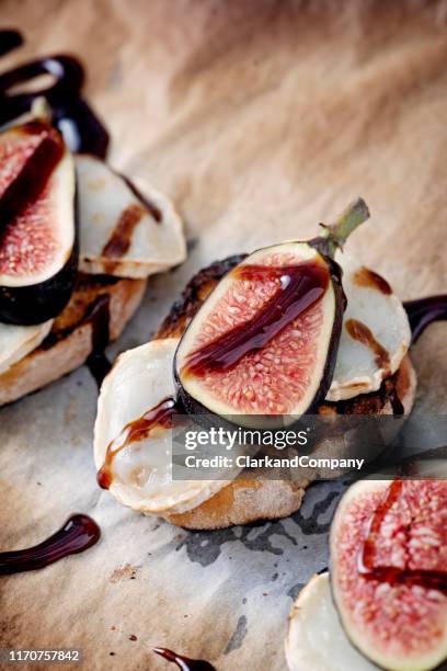 higos frescos con queso de cabra derretido y vinagre balsámico sobre pan tostado. - queso de cabra fotografías e imágenes de stock