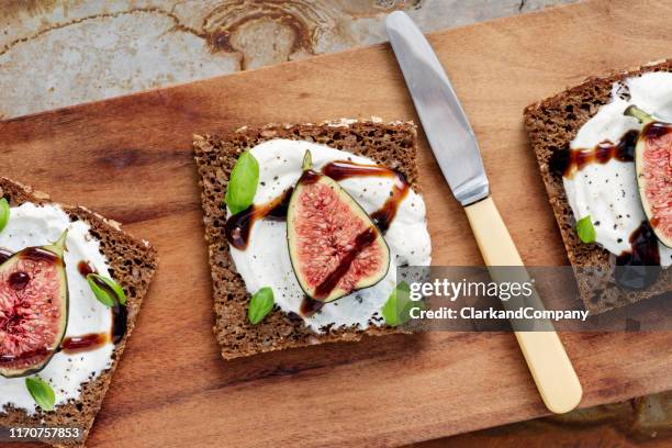 fresh figs, ricotta cheese, fresh basil on rye bread with balsmic vinegar overhead view. - balsamic vinegar stock pictures, royalty-free photos & images